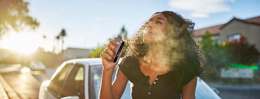 Woman vaping with an adjustable nicotine device